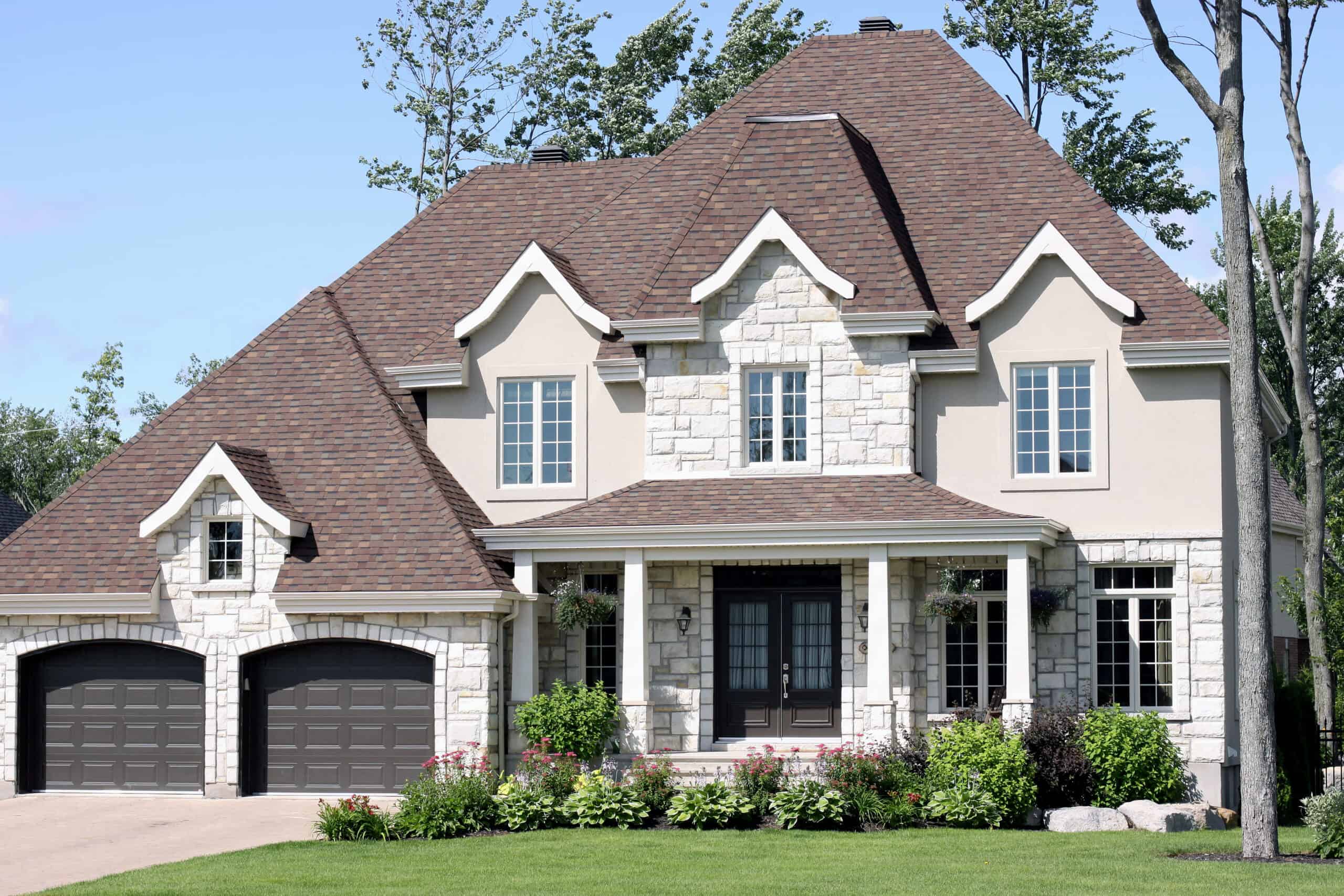 Upscale suburban home in afternoon light with beautiful landscaping